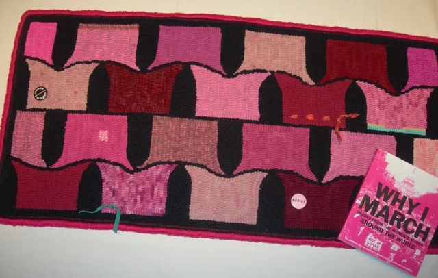 The finished rug and a great book filled with Women's March images from around the world.
