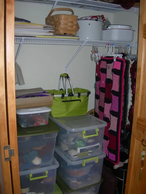 This closet holds dyeing supplies, binding materials and yarn, and you can see that I hang some smaller rugs with "clippy hangers".