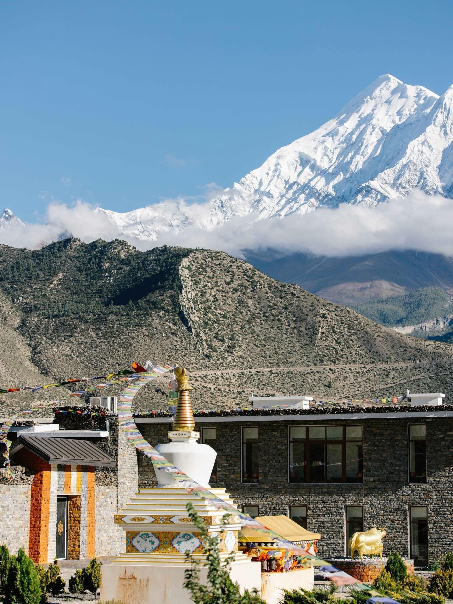 In the remote high-altitude desert of Upper Mustang, close to the Tibetan plateau, Shinta Mani Mustang is reached by winding mountain roads and thin air. The lodge draws from monastic forms and ancient earthen building traditions, using thick adobe w