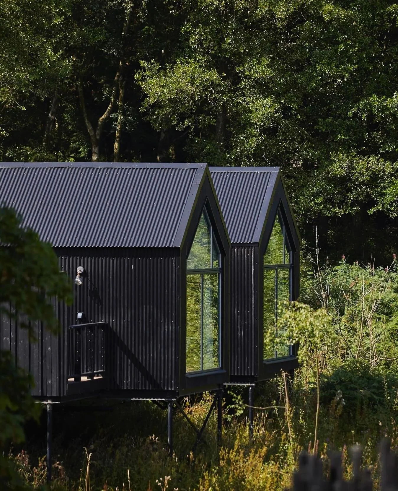 Nestled within the rolling hills of the English countryside, The Tawny transforms historic estate buildings into a collection of treehouses, woodland cabins, and boathouses that combine solitude with understated luxury. Each structure is freestanding