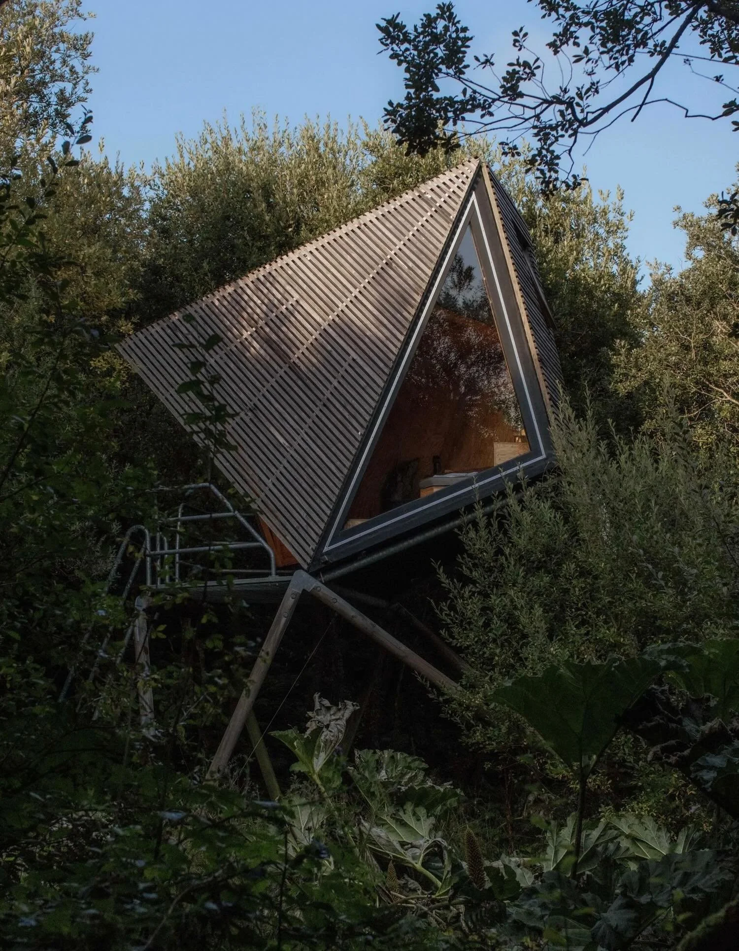 Set within a former slate quarry on the north coast of Cornwall, Kudhva is shaped by a landscape that feels both rugged and elemental. The terrain drops toward the Atlantic, where dense vegetation, exposed rock, and a 40 foot waterfall create a layer