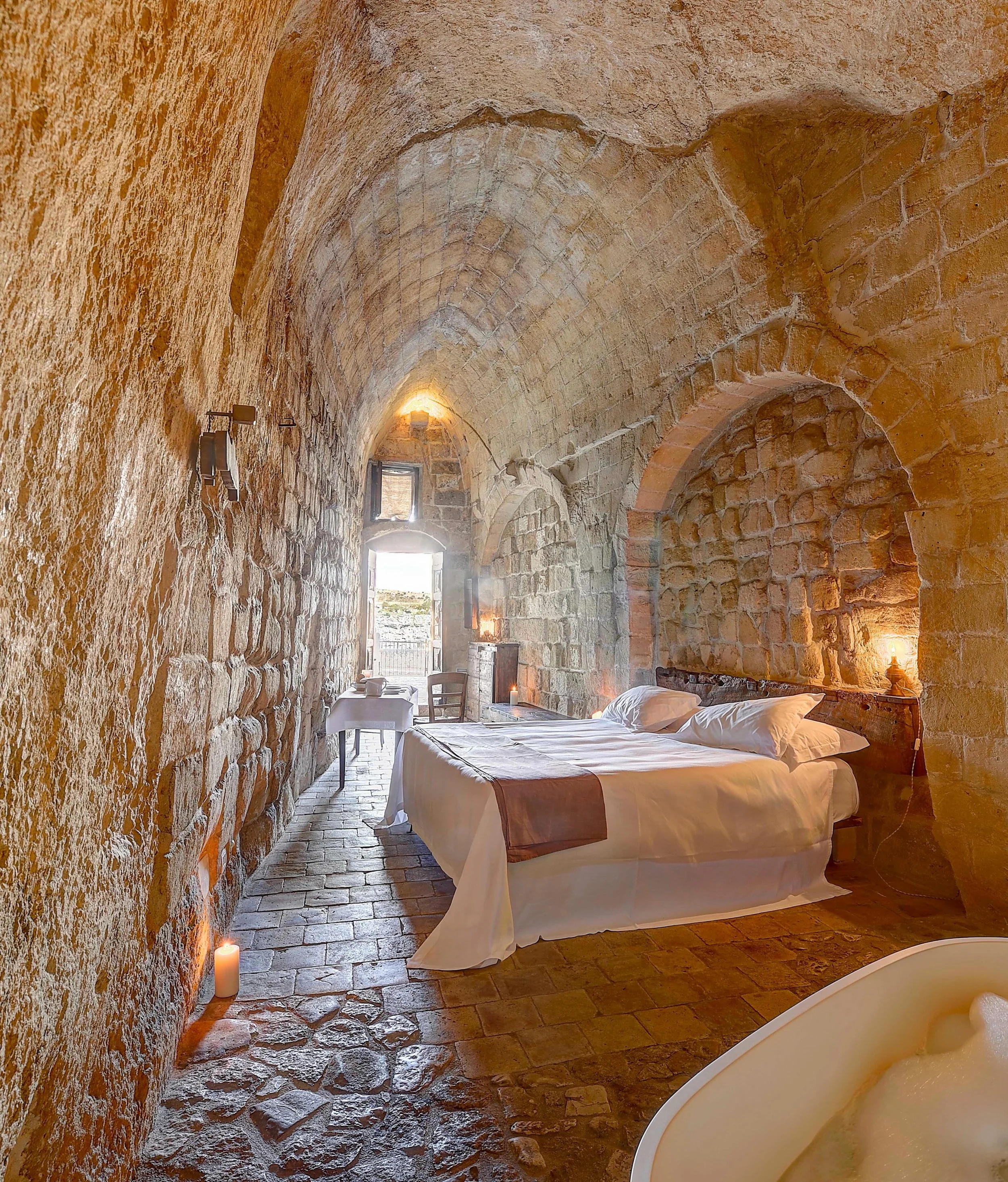 Long before architecture rose above the landscape, it was carved into it. At Sextantio Le Grotte della Civita, guests sleep within the ancient limestone caves of Sassi di Matera, one of the world&rsquo;s oldest continuously inhabited settlements. Sha