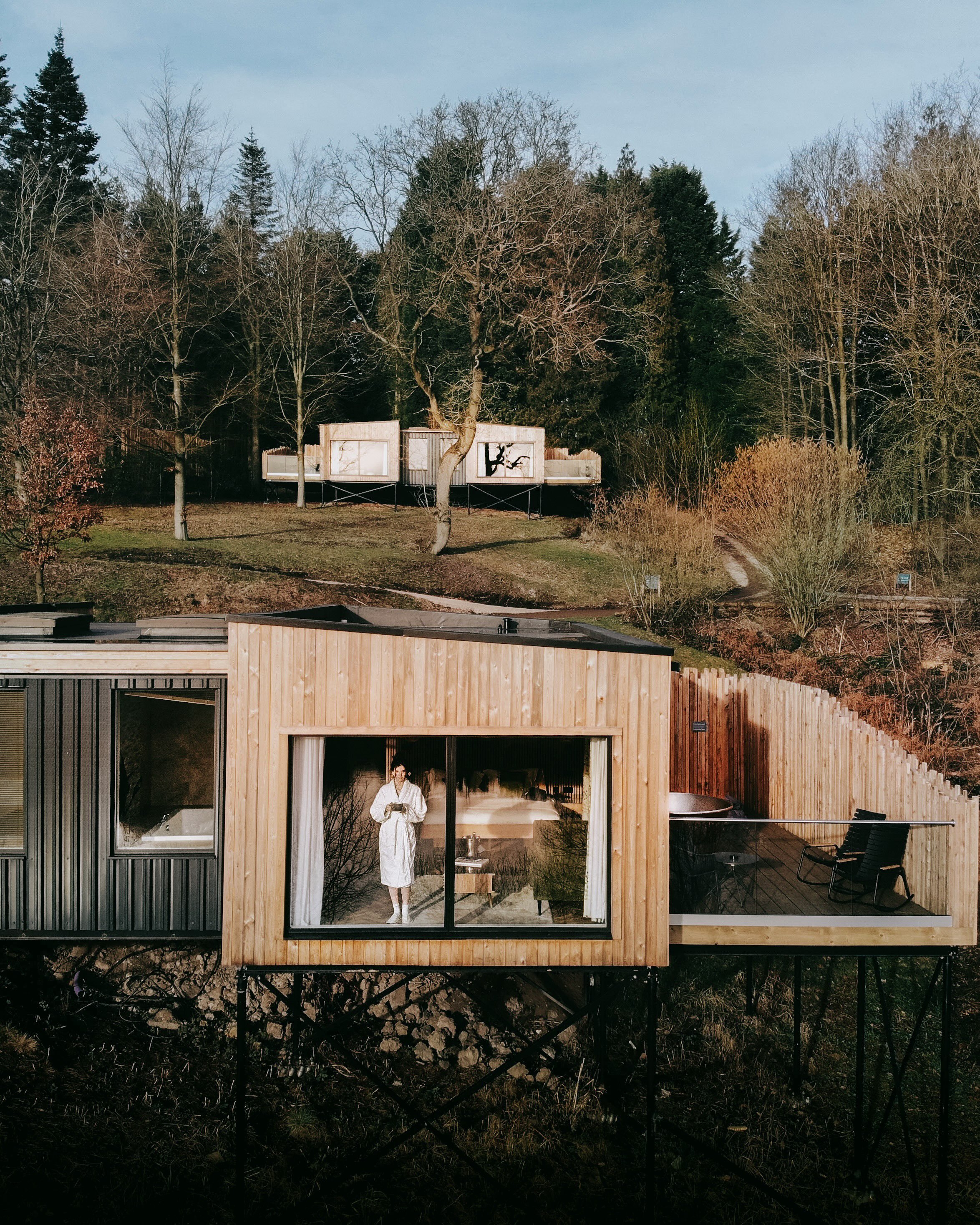 Spanning 70 acres of rewilded estate grounds in the Staffordshire Moorlands, The Tawny Hotel blends low-impact luxury with historic garden architecture. Accommodations range from glass-fronted treehouses to timber lookouts, built directly into the co