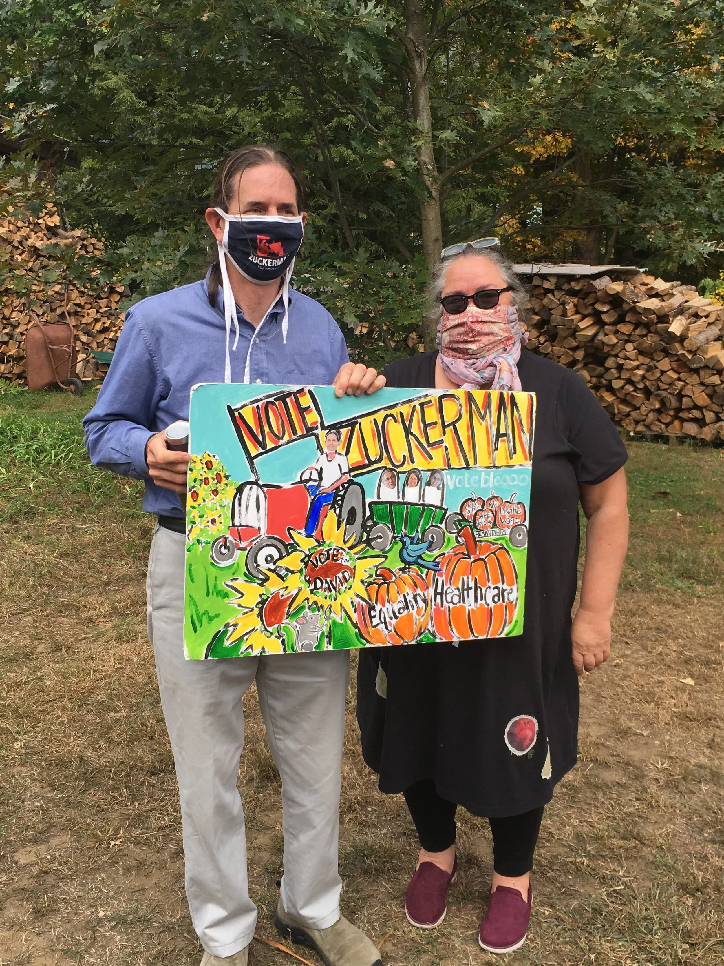 VT Politician David Zuckerman and VT artist Jeanette Staley (both masked) hold handpainted campaign sign 