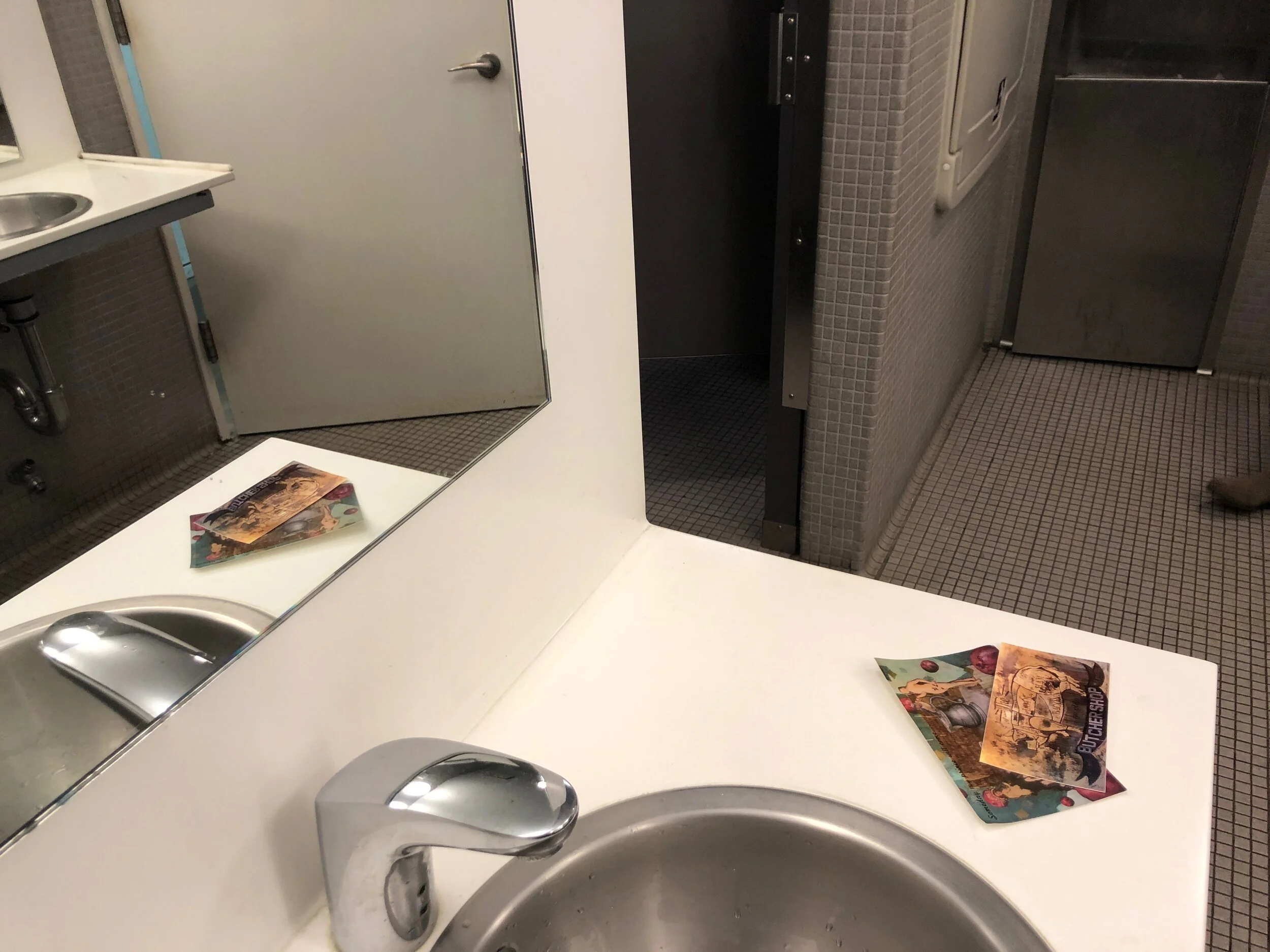 Feminist art postcards left next to sink in public bathroom