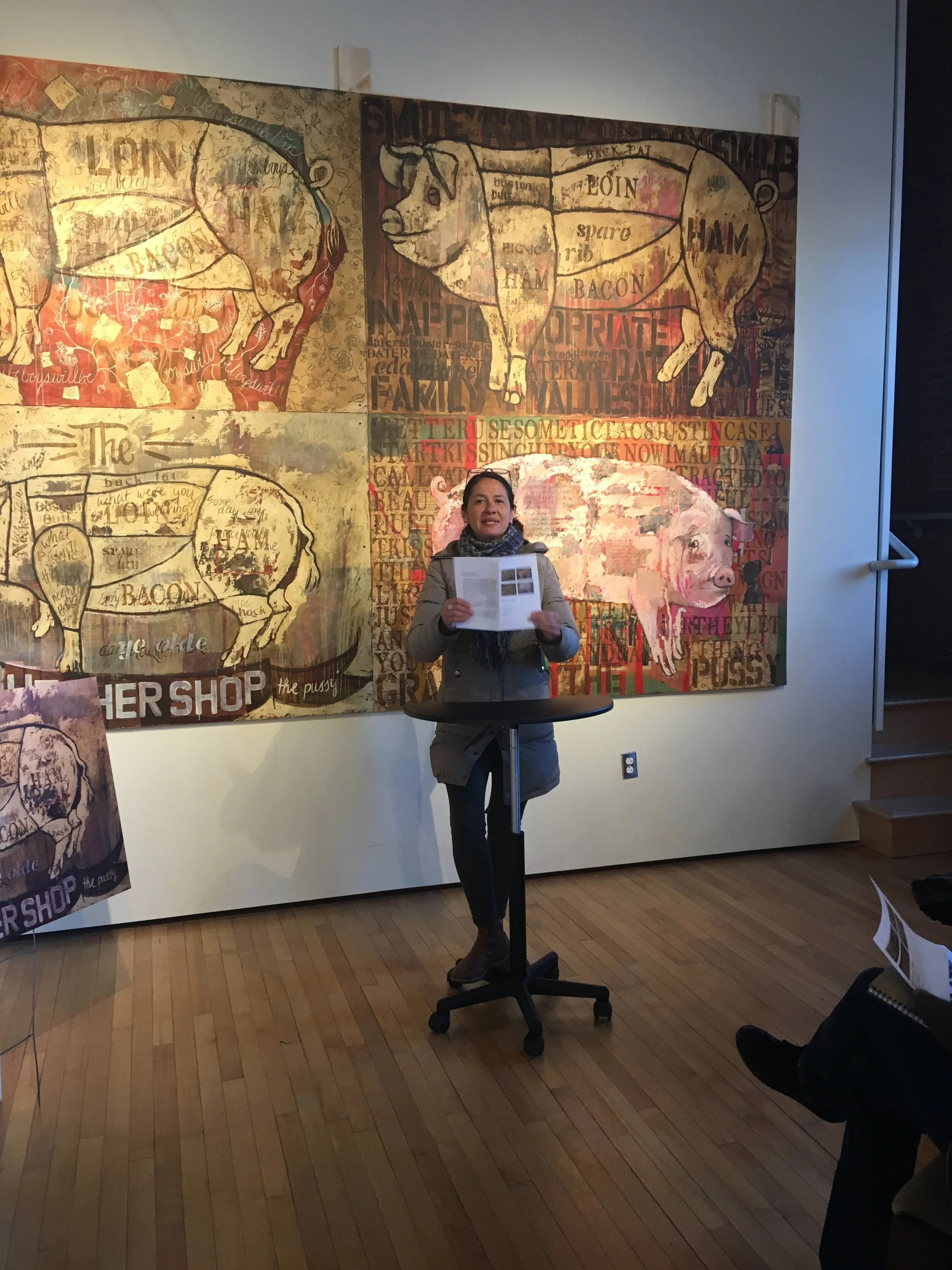 Person standing on front of four Butcher Shop art pieces in gallery 
