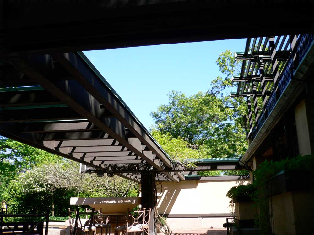 The low, shady terrace trellis opens up to the landscape beyond.