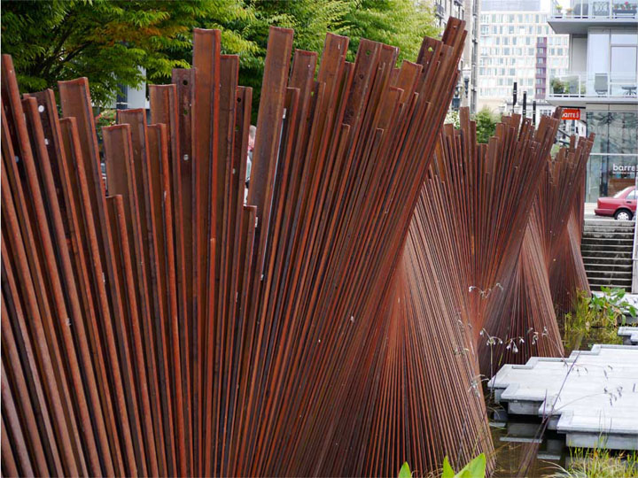 The patina, colour and waving form of this weathered steel screen all create a sinuous, dynamic texture.