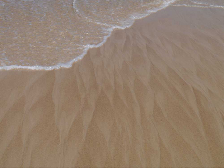  The softness of wet sand washed into braided wave patterns.    