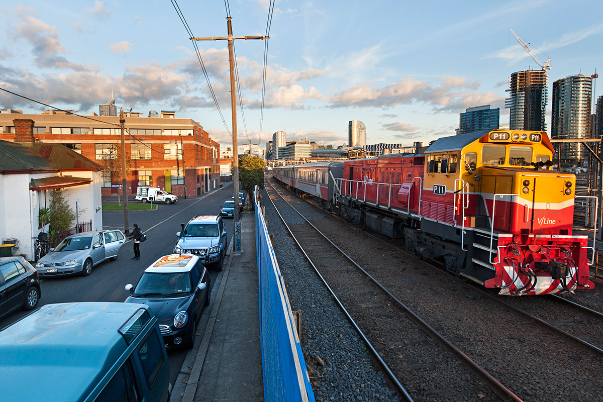 A regional train passing homes on Railway Place, West Melbourne as it approaches the West Melbourne rail flyover. The number of trains using the flyover has increased from about six trains a day in 2010 to over 180 trains a day in 2016. Homes that are less than 15-metres away from the nearest track are noticing a significant increase in vibration induced damage to houses, along with an increase in noise and air pollution.