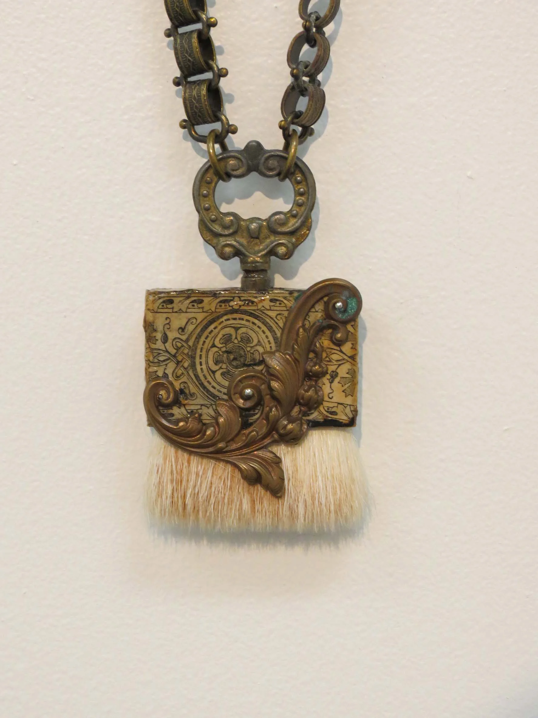  11. Kathy Aspinall, 'Brush II', 2018, wooden brush, clock key, brass, antique paper, book chain, necklace, $295 