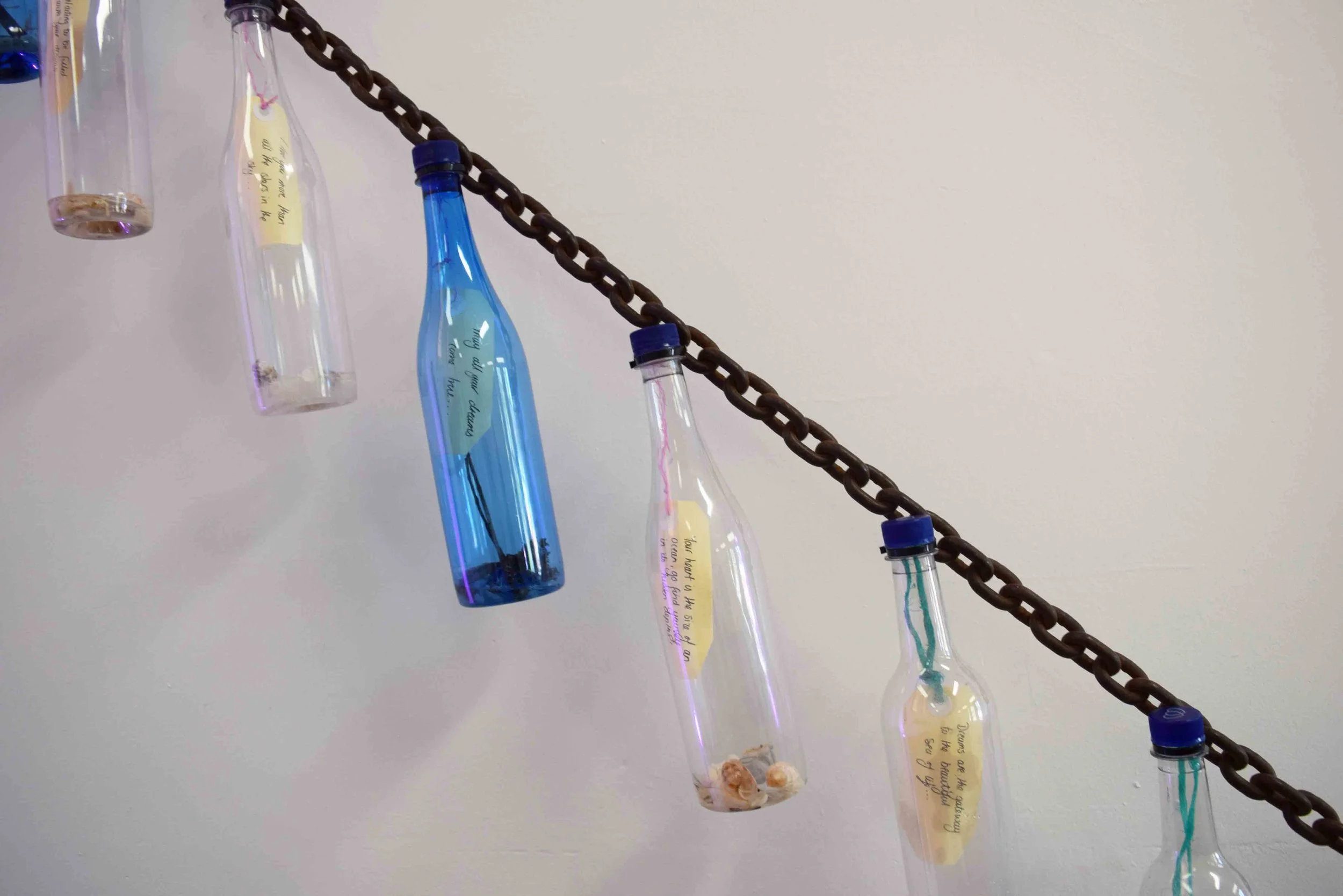  13.  Migration Messages  (detail), 2013, textiles, plastic, card, steel shipping chain, 300 x 10 x 1000 cm. $1,000 