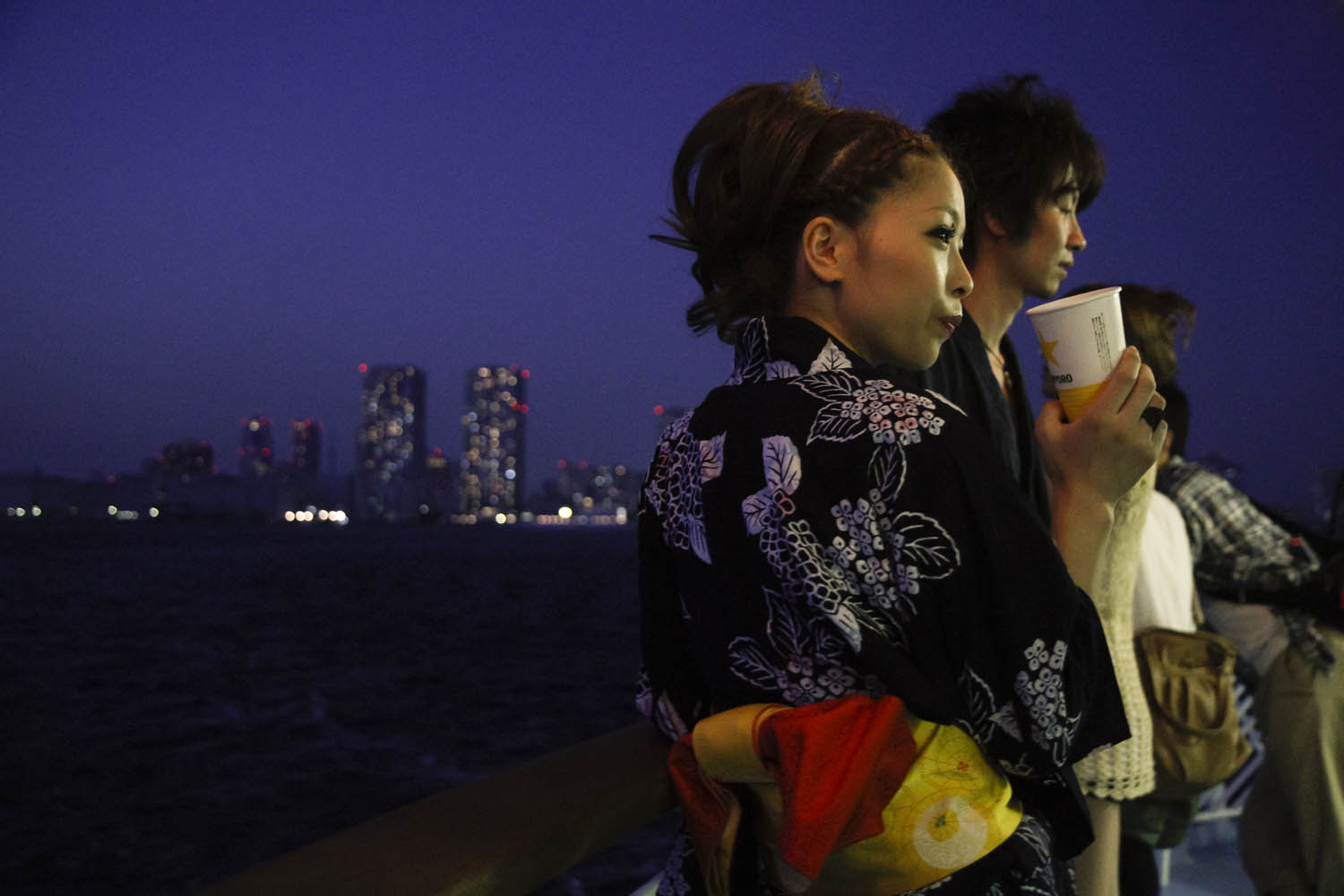A woman wearing traditional Japanese yukata enjoys the atmosphere of the boat cruise on the Tokyo Bay. People were encouraged to wear traditional dress on the two-hour cruise. 