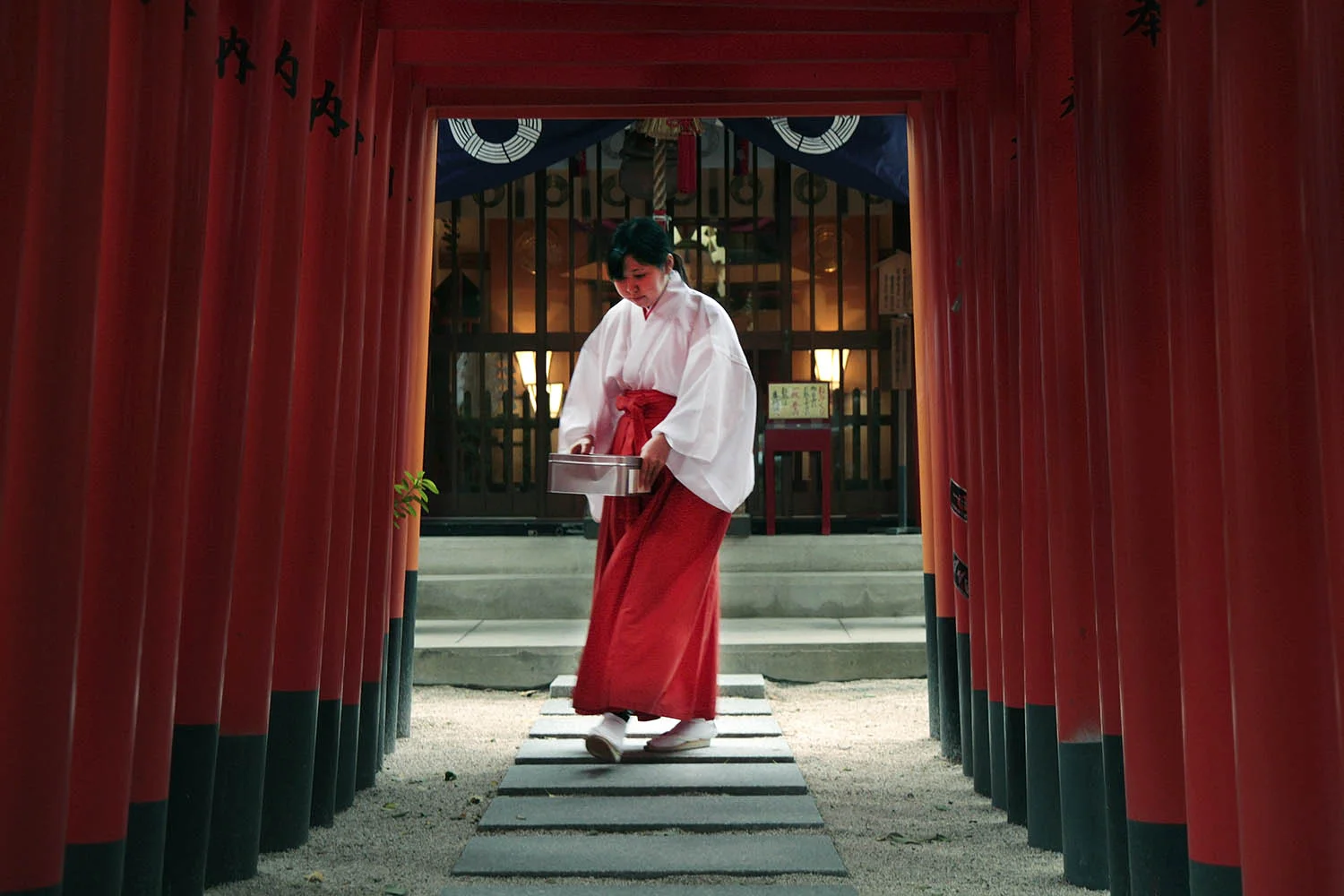 This worker at Kushida Shrine in Fukuoka, Japan, walks under a series of gates carrying a box of donations made to the shrine. Kushida Shrine is famous for a festival in the summer in which participants carry giant floats, some taller than ten meters and weighing over two tons.