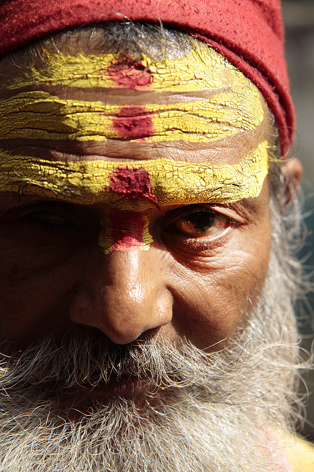  This  sādhu , or holy man, places  tikka , a red spot on the forehead, on people in Kathmandu, Nepal.  Sādhu  live on the edge of society after renouncing material goods.&nbsp; 