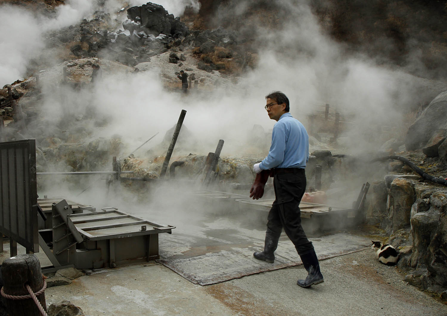  Steam surrounds a worker in Hakone, Japan, as he prepares to extract 黒玉子, or black eggs, from the sulfurous water of a mountain hot spring. The eggs boiled in the water take on a black color from the sulfur. According to legend, eating one of these 