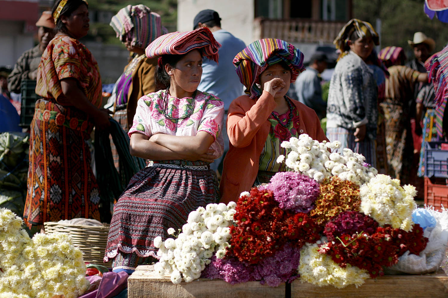  Women sell flowers in an outdoor market in Zunil, a small town near Quetzaltenango, Guatemala. At the market an announcer advertised items over a loudspeaker as farmers hurried around the square carrying huge bushels of vegetables. 