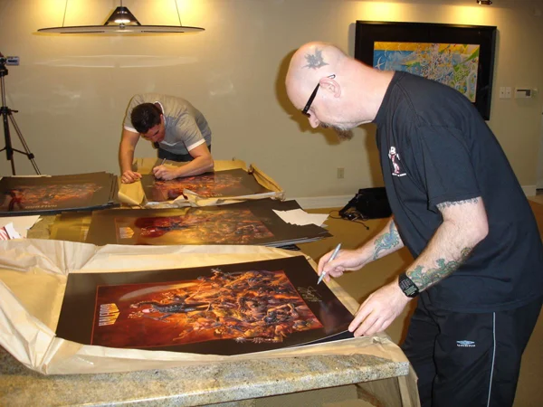 Marc Sasso and Rob Halford of Judas Priest signing Hell Brawl limited edition prints.