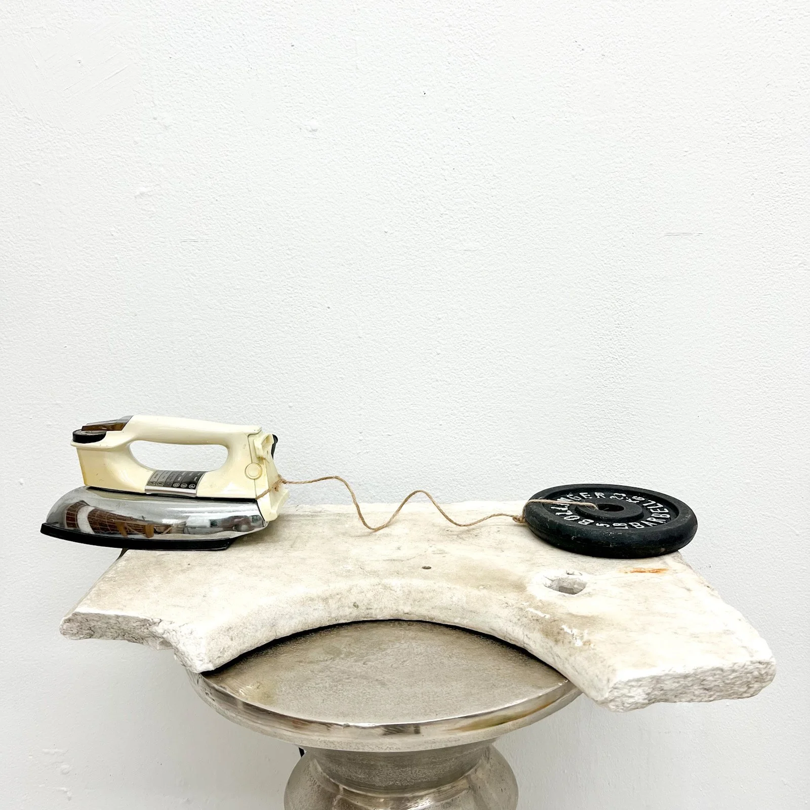  'Weight', 26.5 x 7.5, 2024, Round iron weight, clothing iron, twine.  