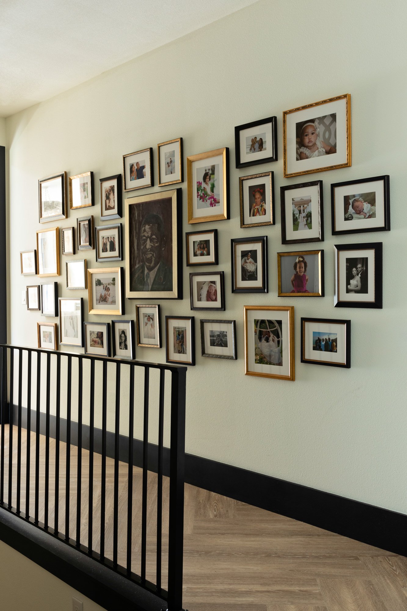 A hallway decorated with a large gallery of framed family photos and portraits.
