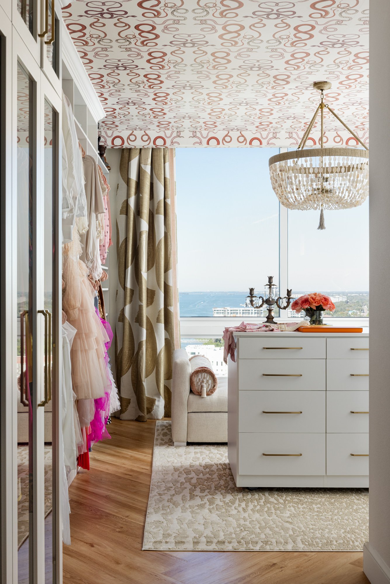 Dressing room with patterned ceiling wallpaper, chandelier and ocean view