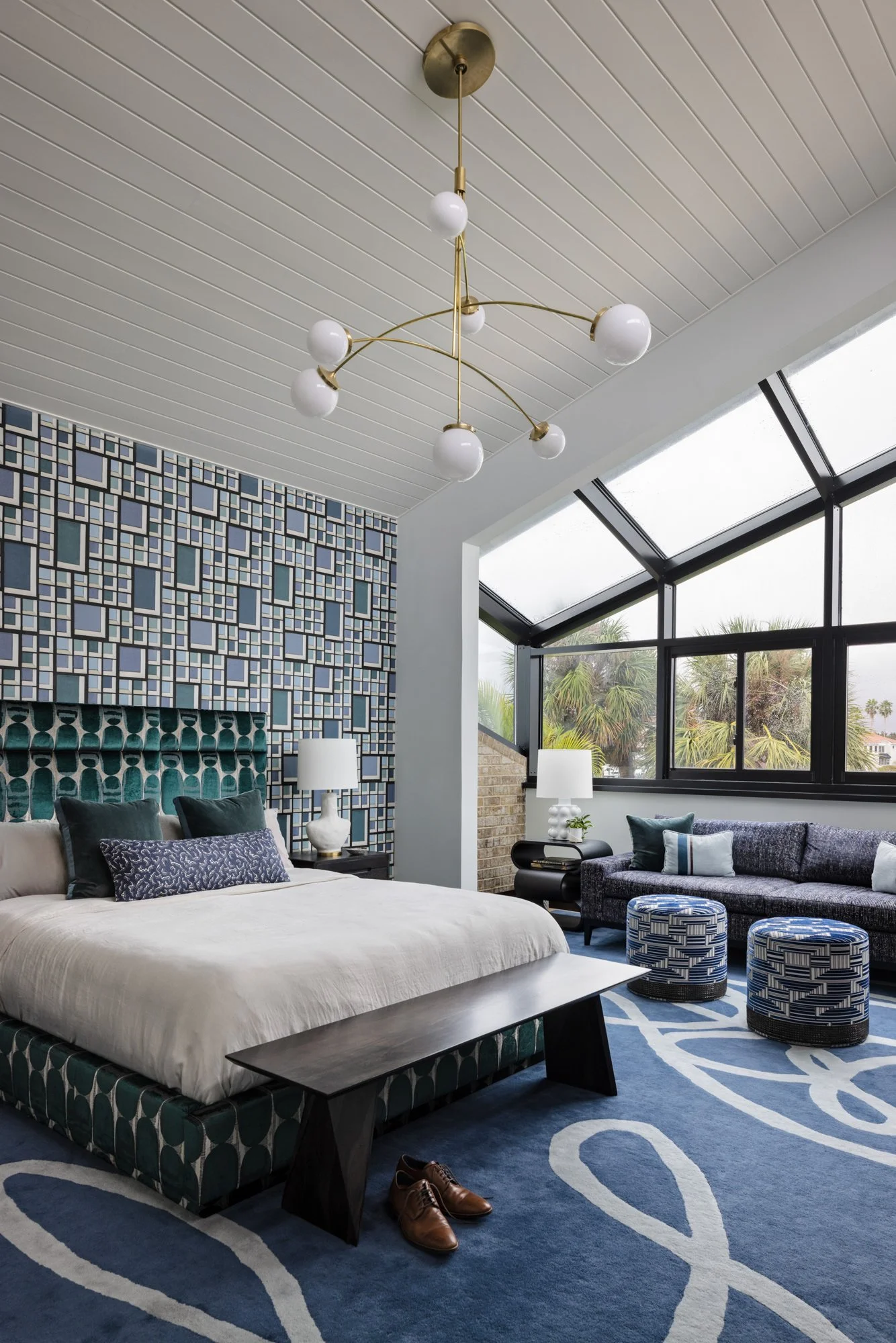 Primary bedroom with geometric wallpaper, vaulted ceiling and large windows