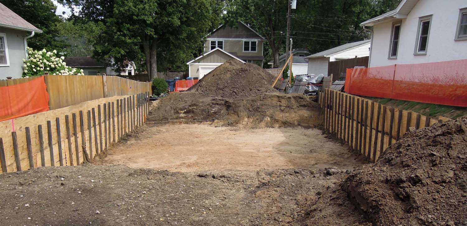 Excavation has been completed for the garage and porch pier footings. Next week should see the forming, reinforcing and pouring of the footings, including the dual drain tile - radon vent interconnects. I have a special ceremony planned for the center column footing as the concrete is poured. Stay tuned.