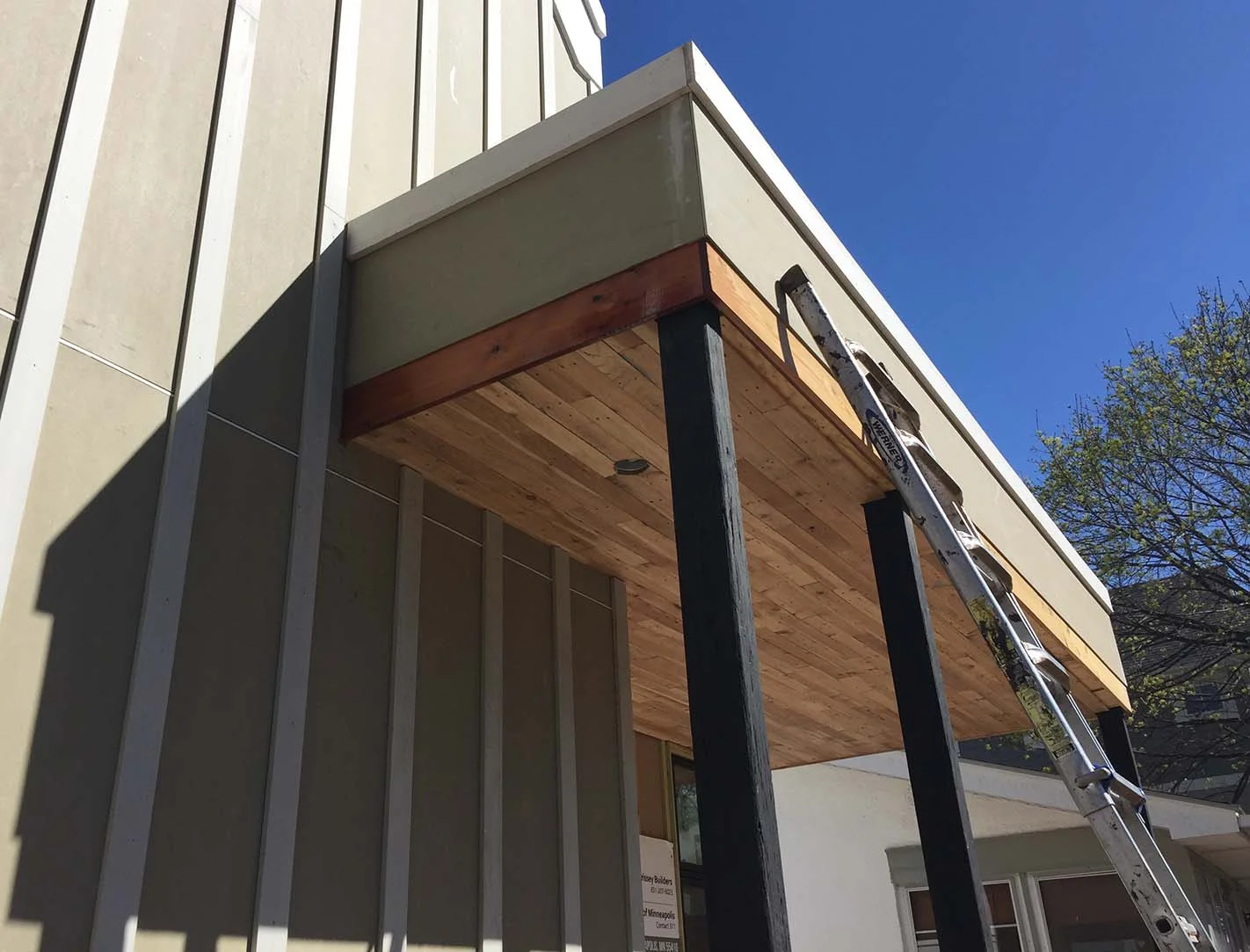 The warm stained cedar will closely match the fir front door finish and will mediate between the deep blue board-and-batten walls and the white lap siding walls. The black-stained PSL columns will get another coat and there will be additional framing infill to create the screen frame supports (ScreenEze) and screened door.