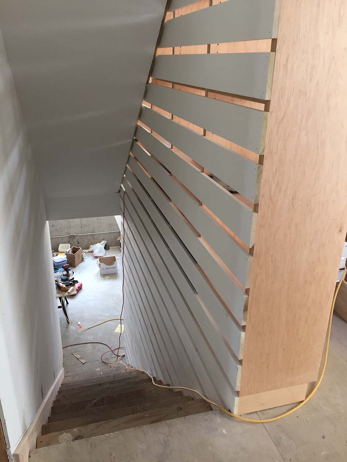 This image shows the slats alongside the stairwell. They are continuous from the basement through the top level, providing the code-mandated barrier while allowing peek-a-boo glimpses through it.