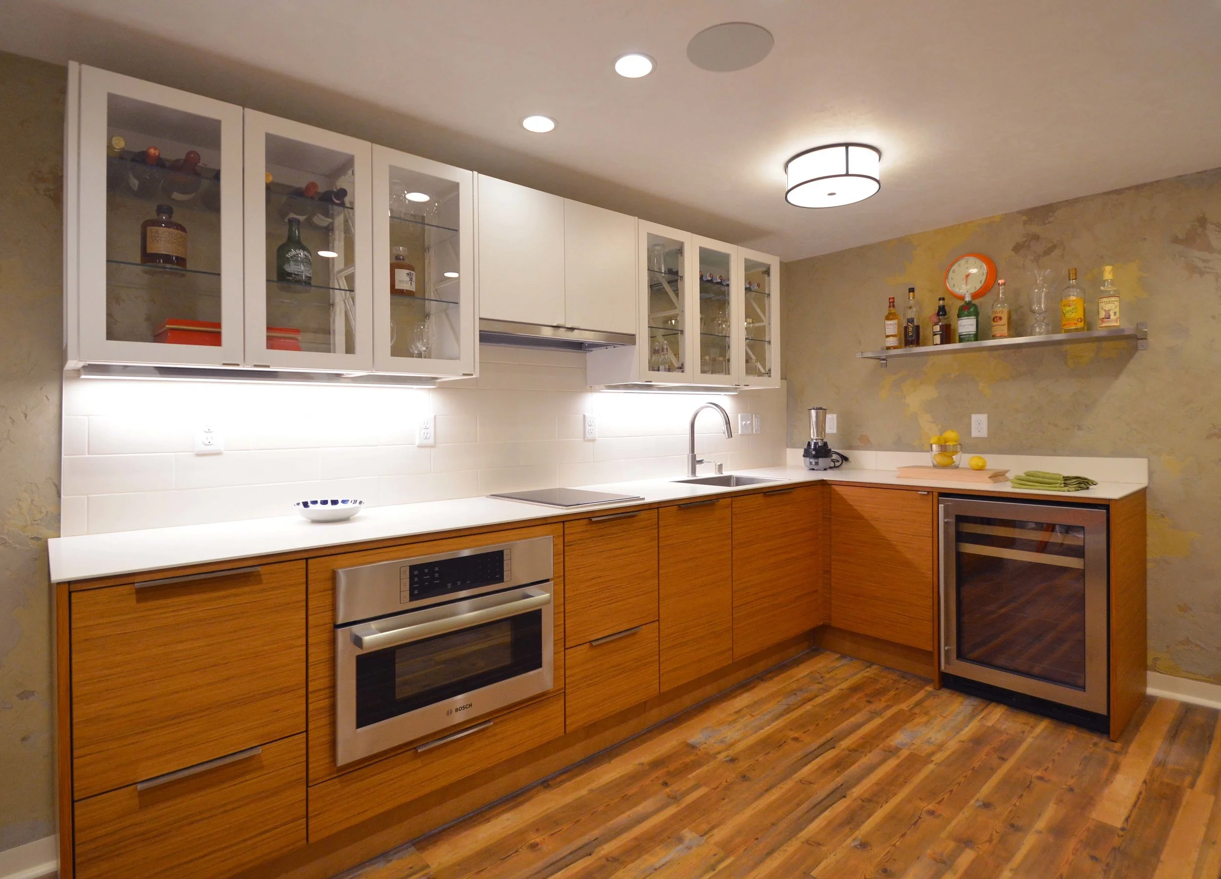  This basement kitchenette features Puustelli cabinetry and countertops.  The innovative upper cabinets allow the multi-toned wall plaster to show through. 
