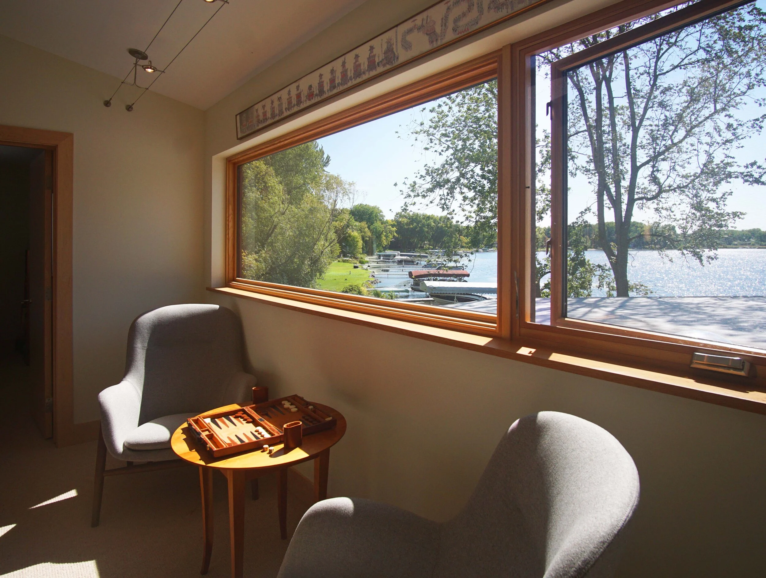  With the home design emphasizing aging in place for the owners, the smaller upper level is devoted to a pair of bedrooms for their visiting adult children and guests.  This sitting area in the corridor overlooks the lake. 