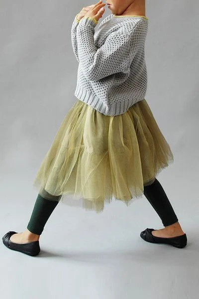 A Beautiful alternative to the Classic Pink Tutu is this Olive Bellanie Tutu from Wunway.com . It is truly a Tutu Skirt for Little Fashionistas- this airy Tutu features layers of tiered ruffles and has a corsage accent on the waist for Extra Cuteness. I also love how it is worn with a casual grey sweater, black leggings, and black ballet flats… Tres Chic!