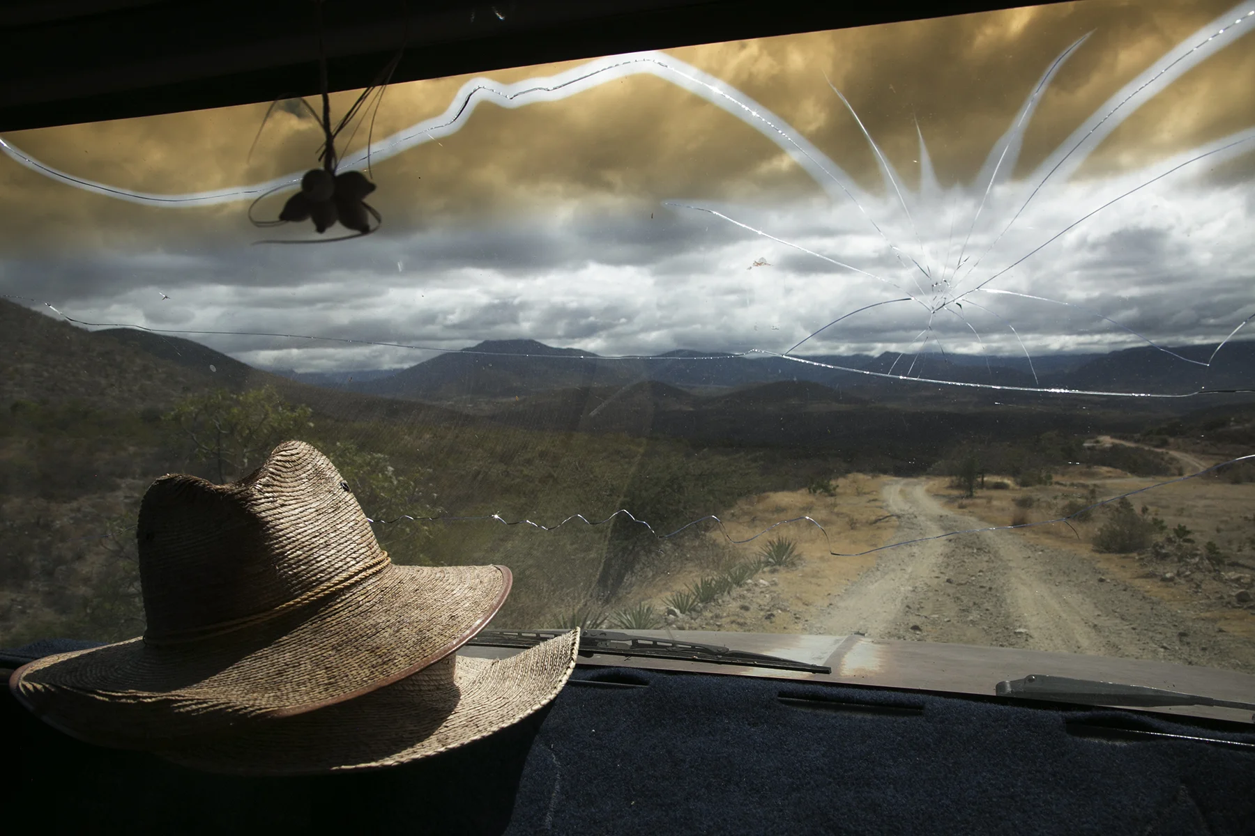 Augustin Guendulain's windshield is cracked from an accident while driving after drinking too much mezcal. It is an imprint of his friend's head. 
