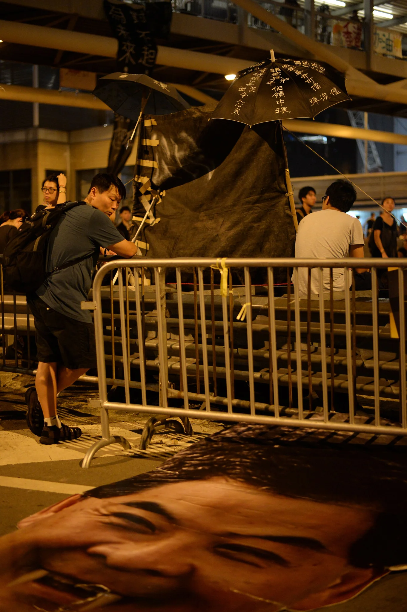A man considers the discarded head of Chief Executive CY Leung as a vampire. The vampire cutout had first appeared moving through the huge crowds of Admiralty on Monday night, where it was loudly booed.