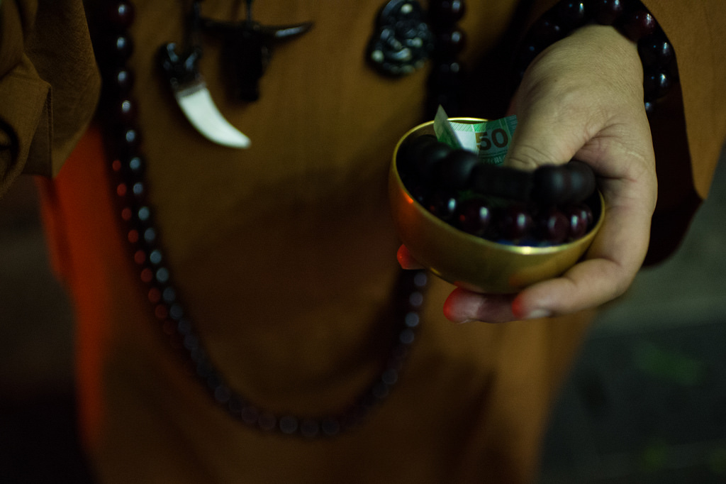 the monk is bunk: heavily-touristed parts of the city are patrolled by men dressed as monks, asking for donations and selling wooden bracelets. in this photo, the monk's alms bowl, which traditionally is used to accept rice, is stuffed with money an