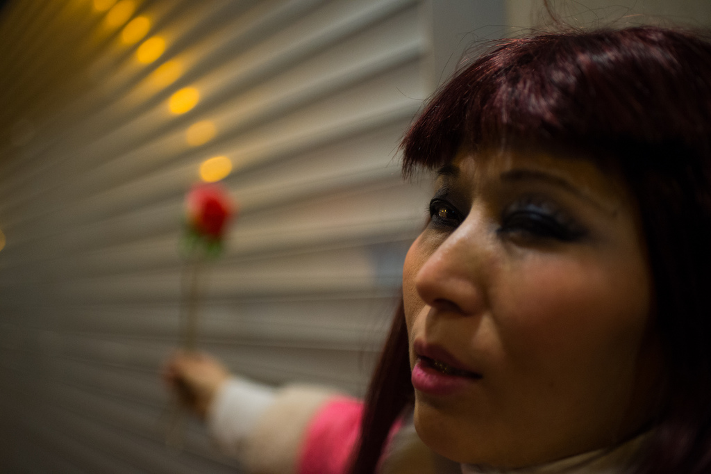 this woman works late into the night selling artificial flowers to partygoers in lan kwai fan and wan chai. 