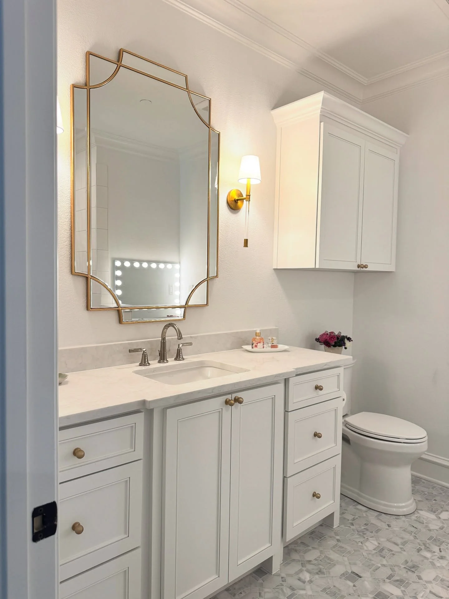 Timeless Touches + a Hint of Glam: Bathroom Reveal 

Swipe to see the before and after of this classic bathroom transformation. We removed the dated finishes, bath tub and warm tones and replaced them with a bright white palette, timeless cabinetry, 