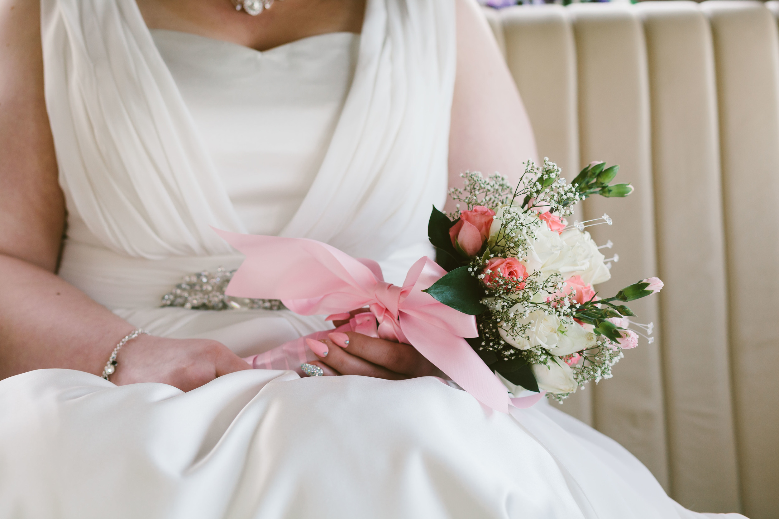 Durham Wedding Photographer South causey Inn Bride holding white and red bouquet in front of wedding car