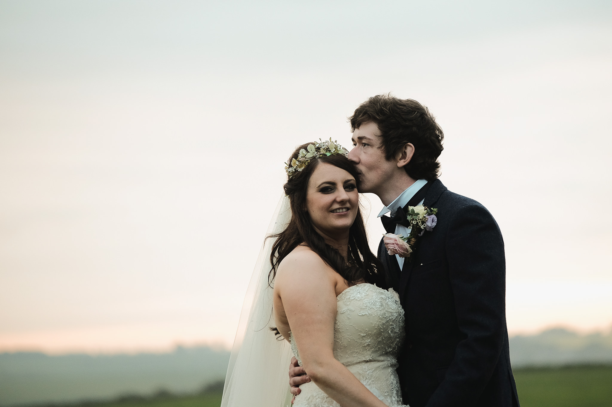 The bride and groom cuddle at Newton Hall, Northumberland by Barry Forshaw