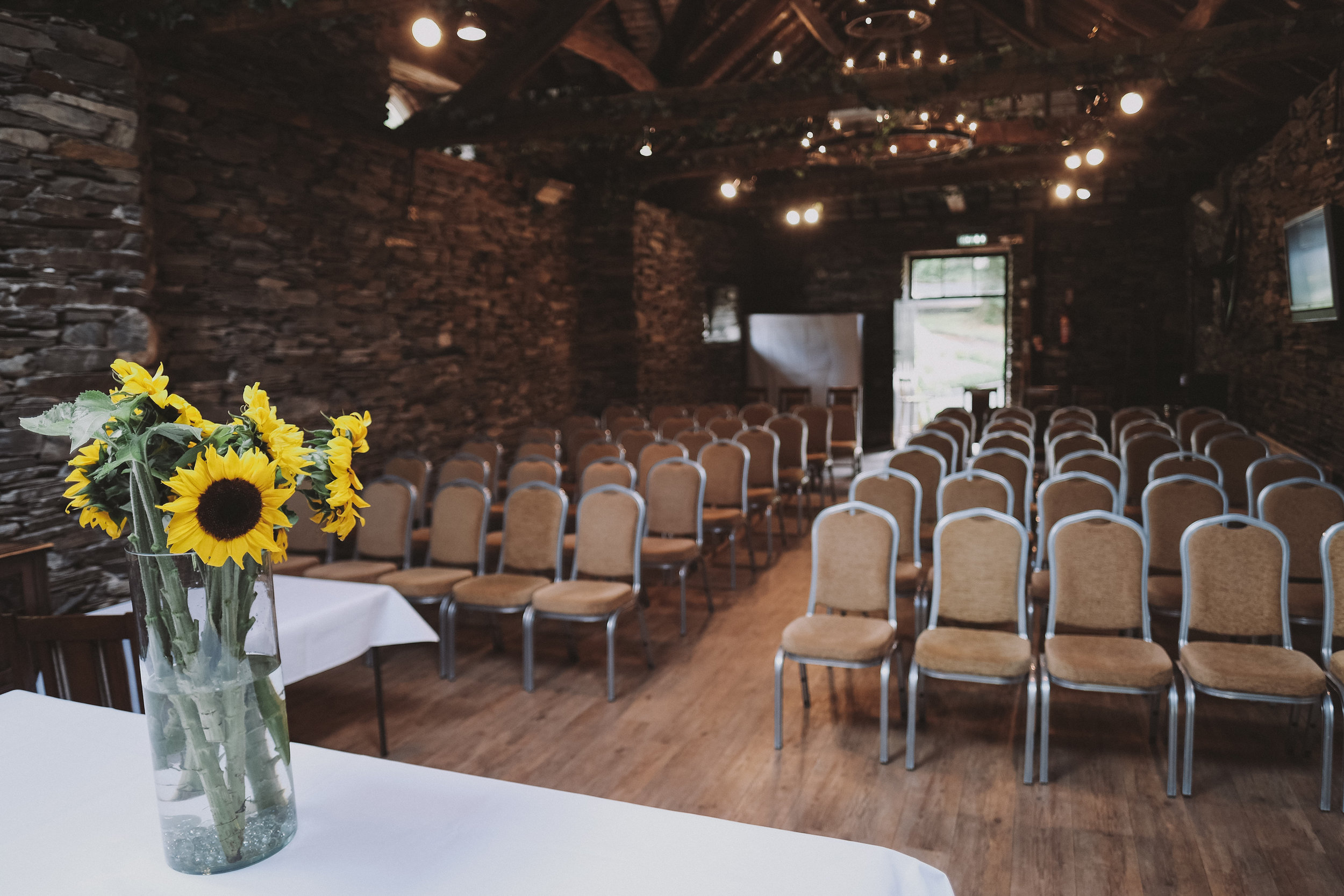 Sunflowers decorate the slate barn at Julia and Darren's Lake District wedding by Barry Forshaw