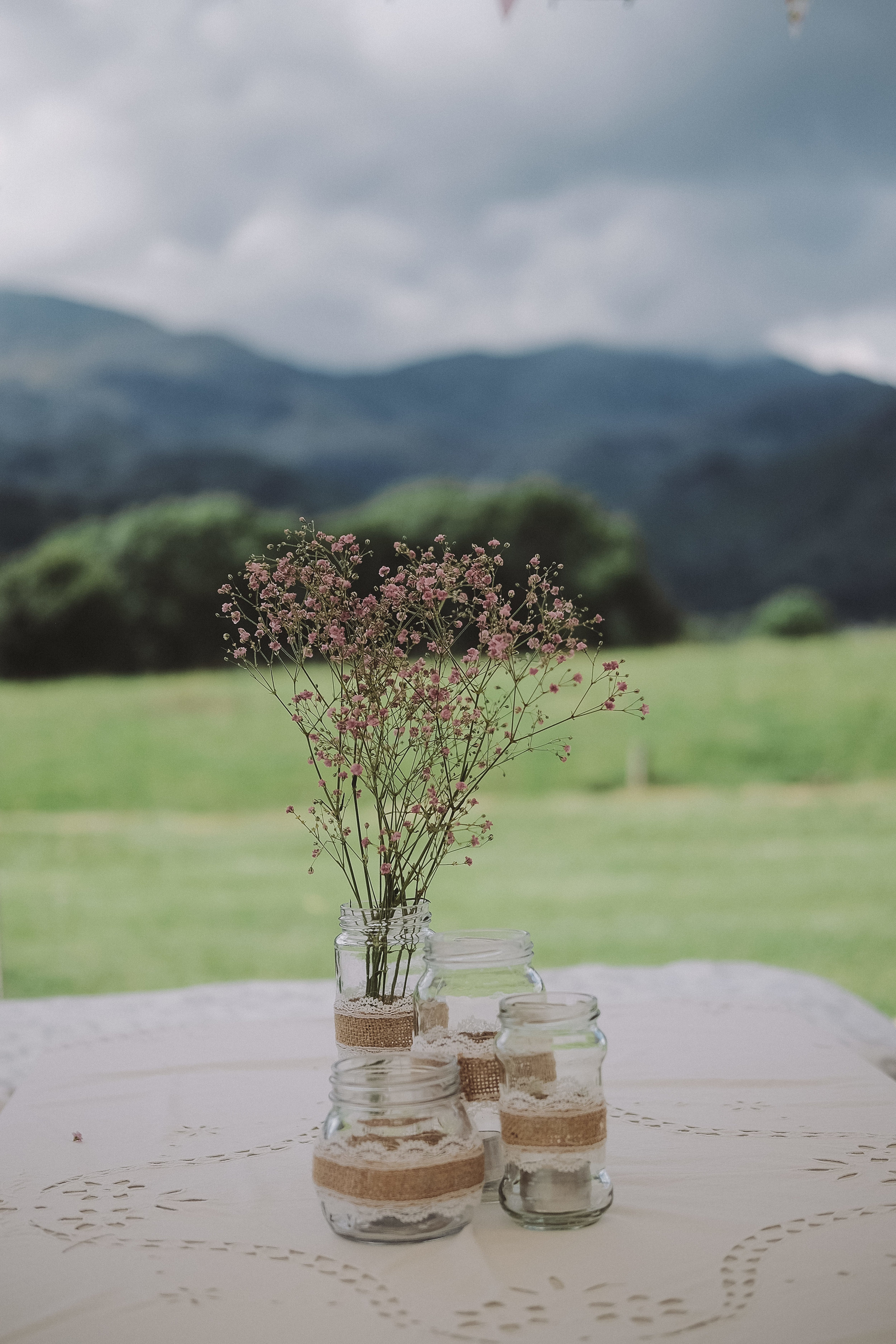 A flower centrepiece with the hills of the Lake District in the background at Julia and Darren's Lake District wedding by Barry Forshaw