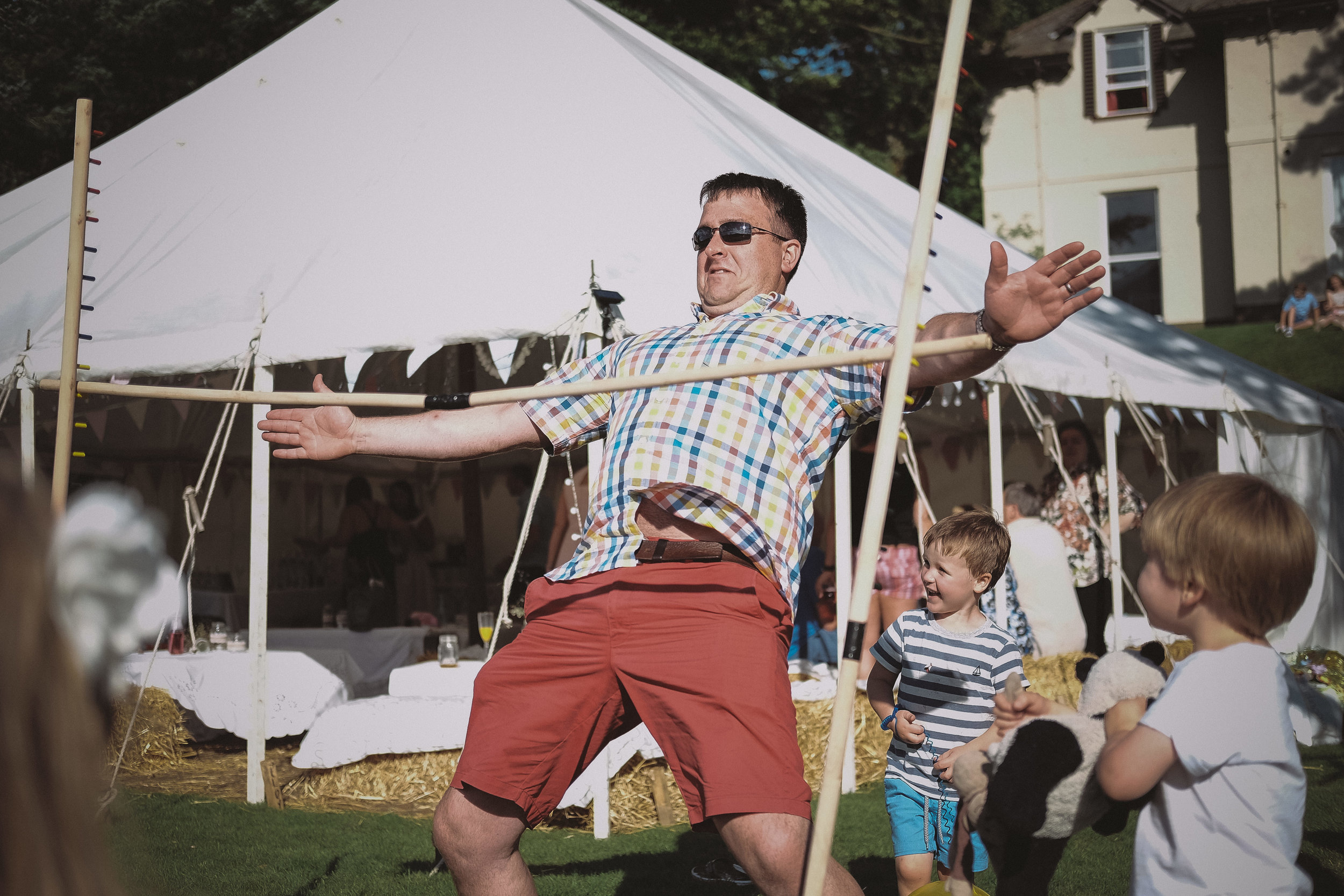A wedding guest limbo dances at Julia and Darren's Lake District wedding by Barry Forshaw