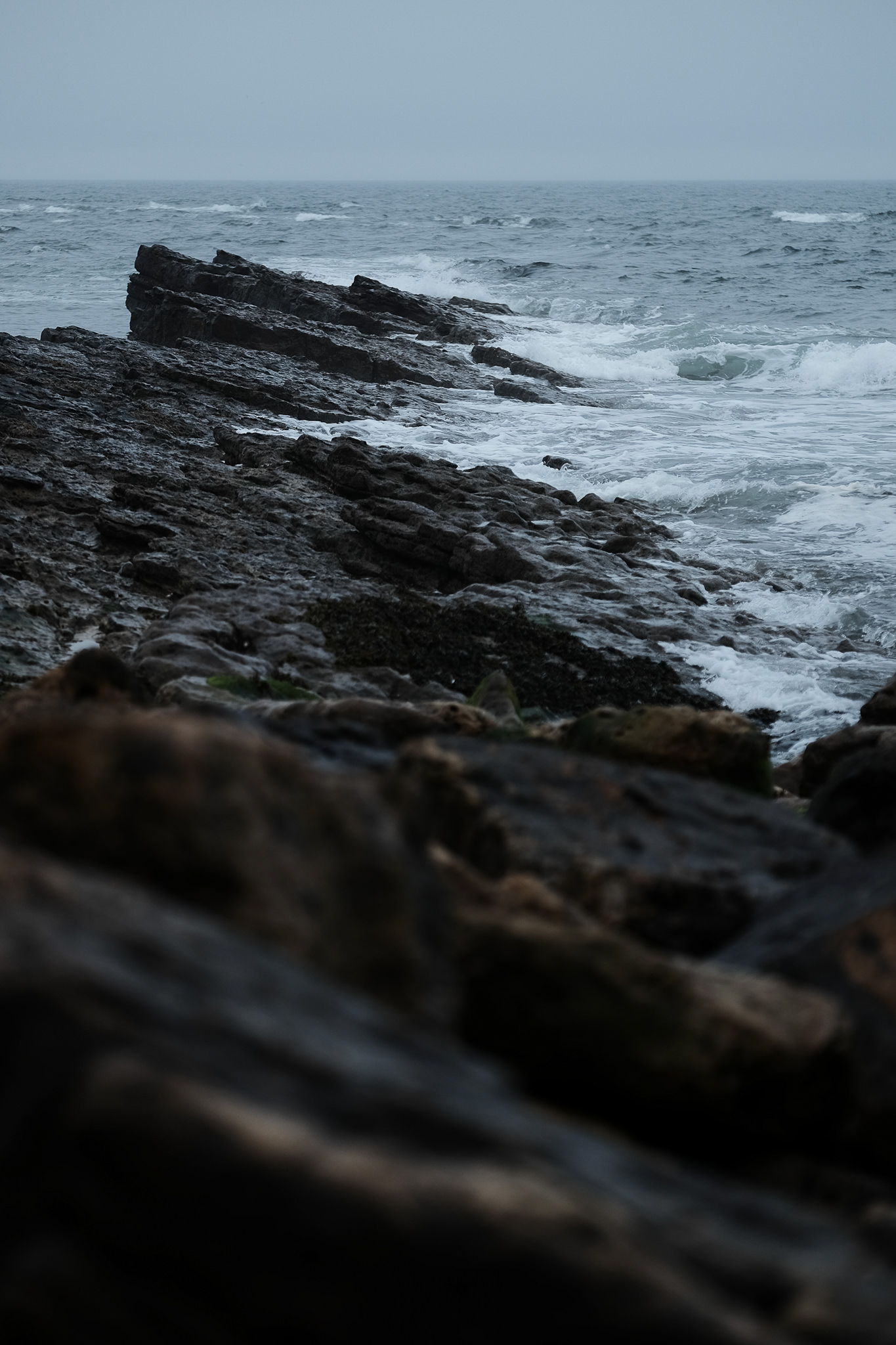 Stormy seas break on jagged rocks on the Northumberland coast