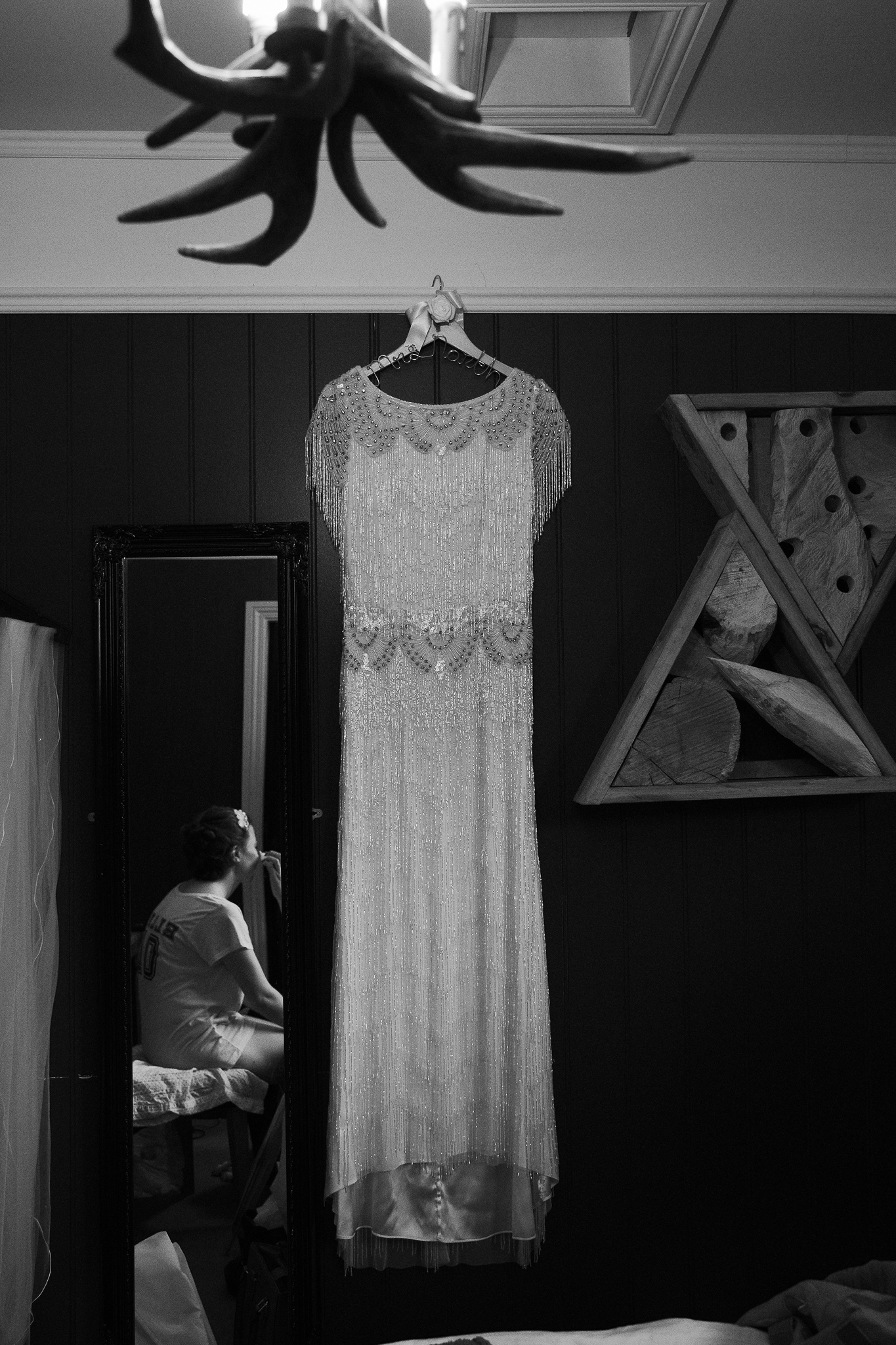 Balckand white photo of wedding dress hanging in hotel room