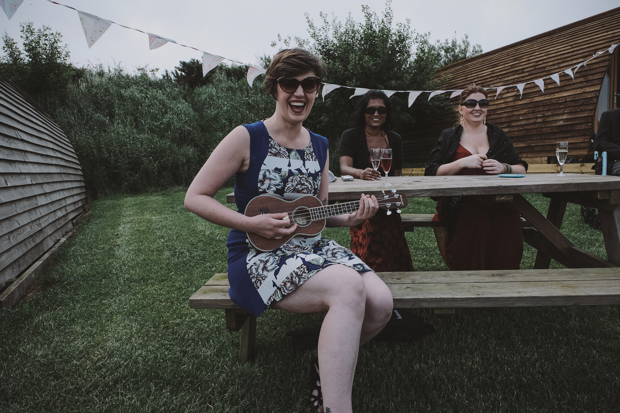 The brides entrance is accompanied by a sunglasses wearing ukulele player