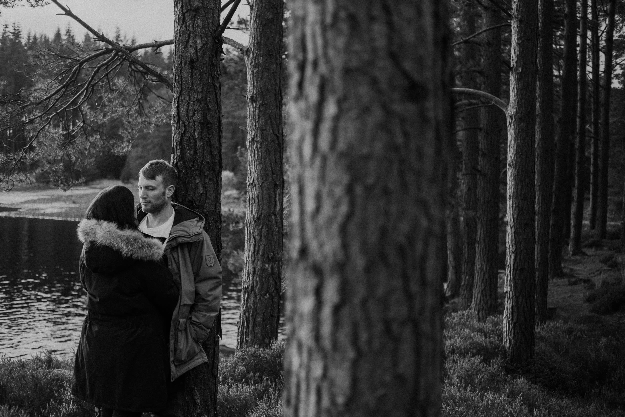 Black and white photo of a couple cuddling in Kielder Forest