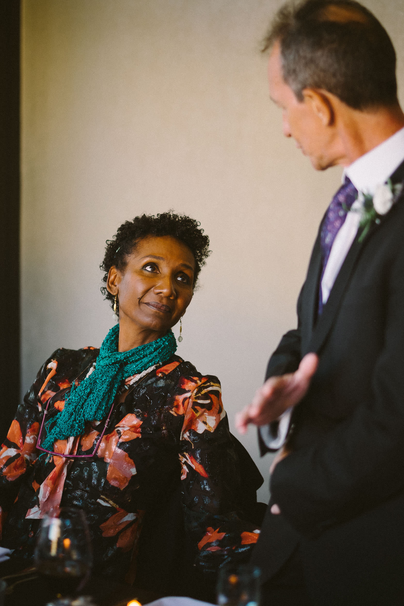 Mother of the groom looks tenderly at father of the bride during his wedding speech