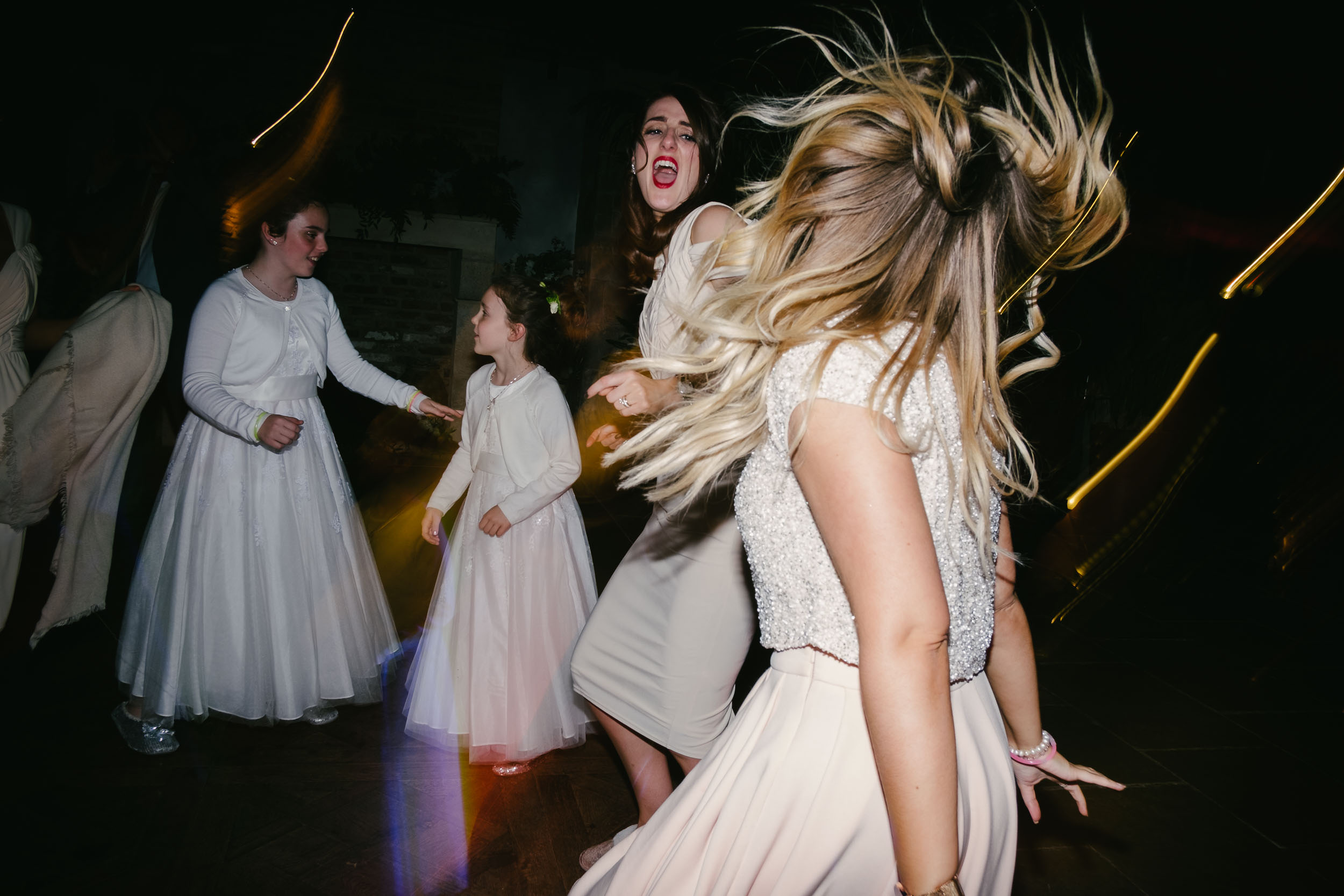 Bridesmaids dance with hair flying at Le Petit Château