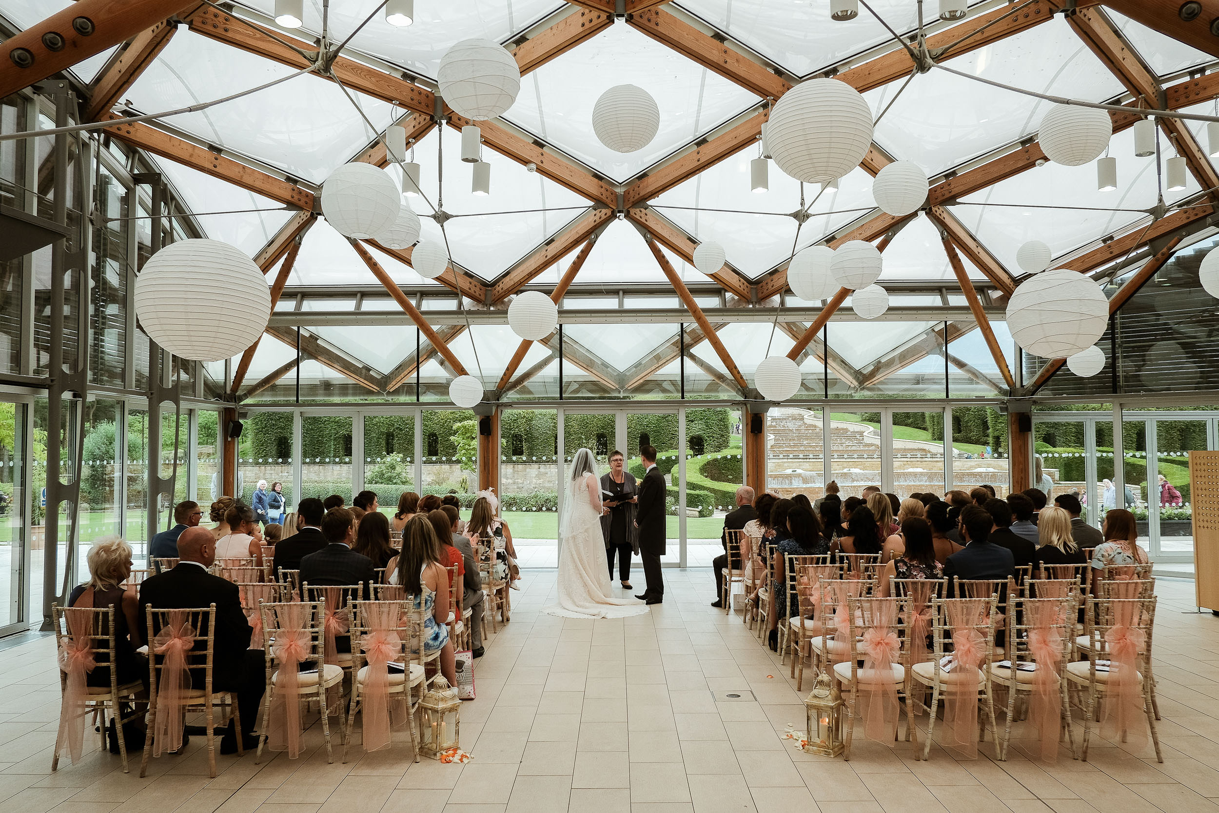 Wide shot of bride and groom and wedding party at the Alnwick Garden wedding ceremony