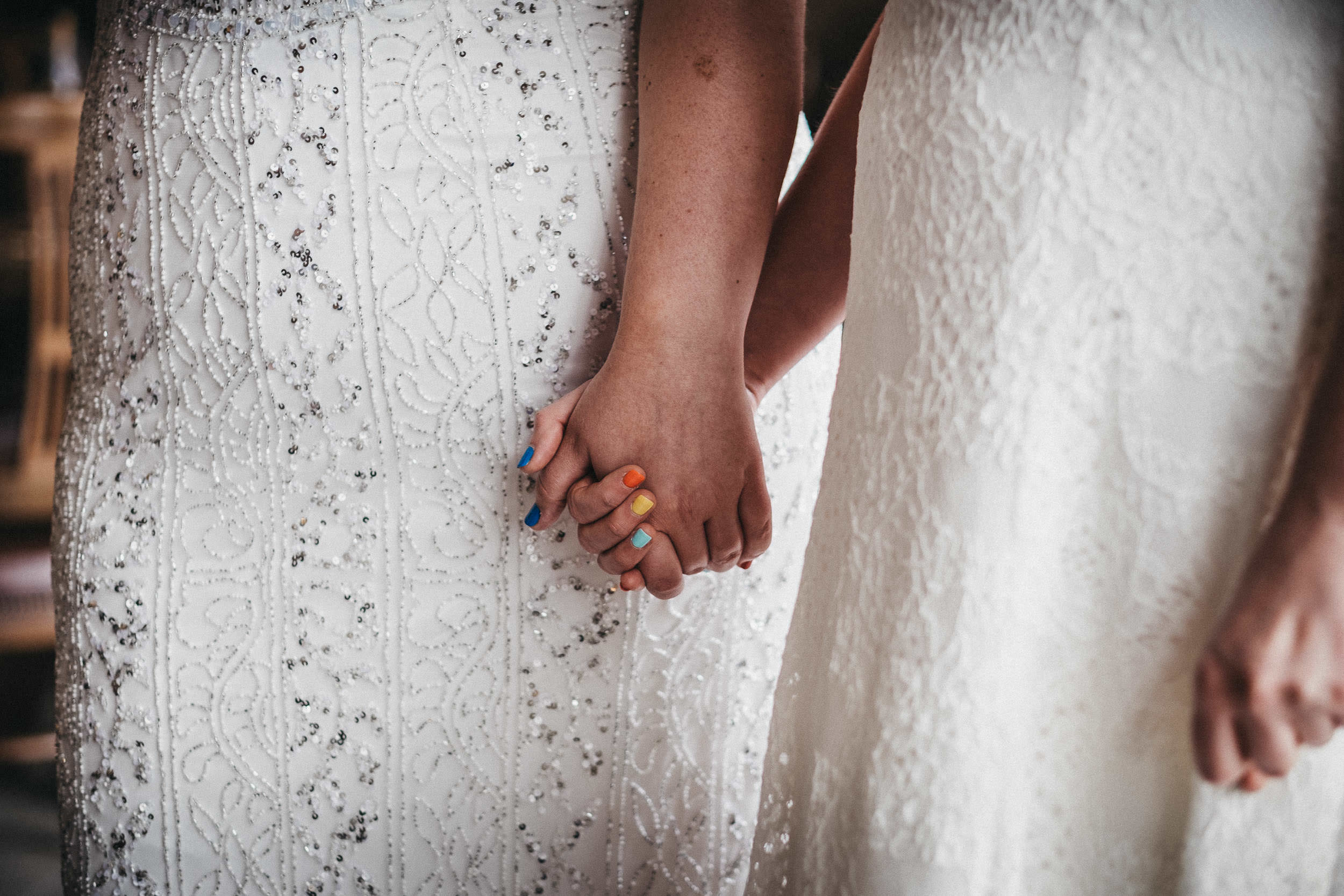 Lesbian brides hold hands at same sex wedding